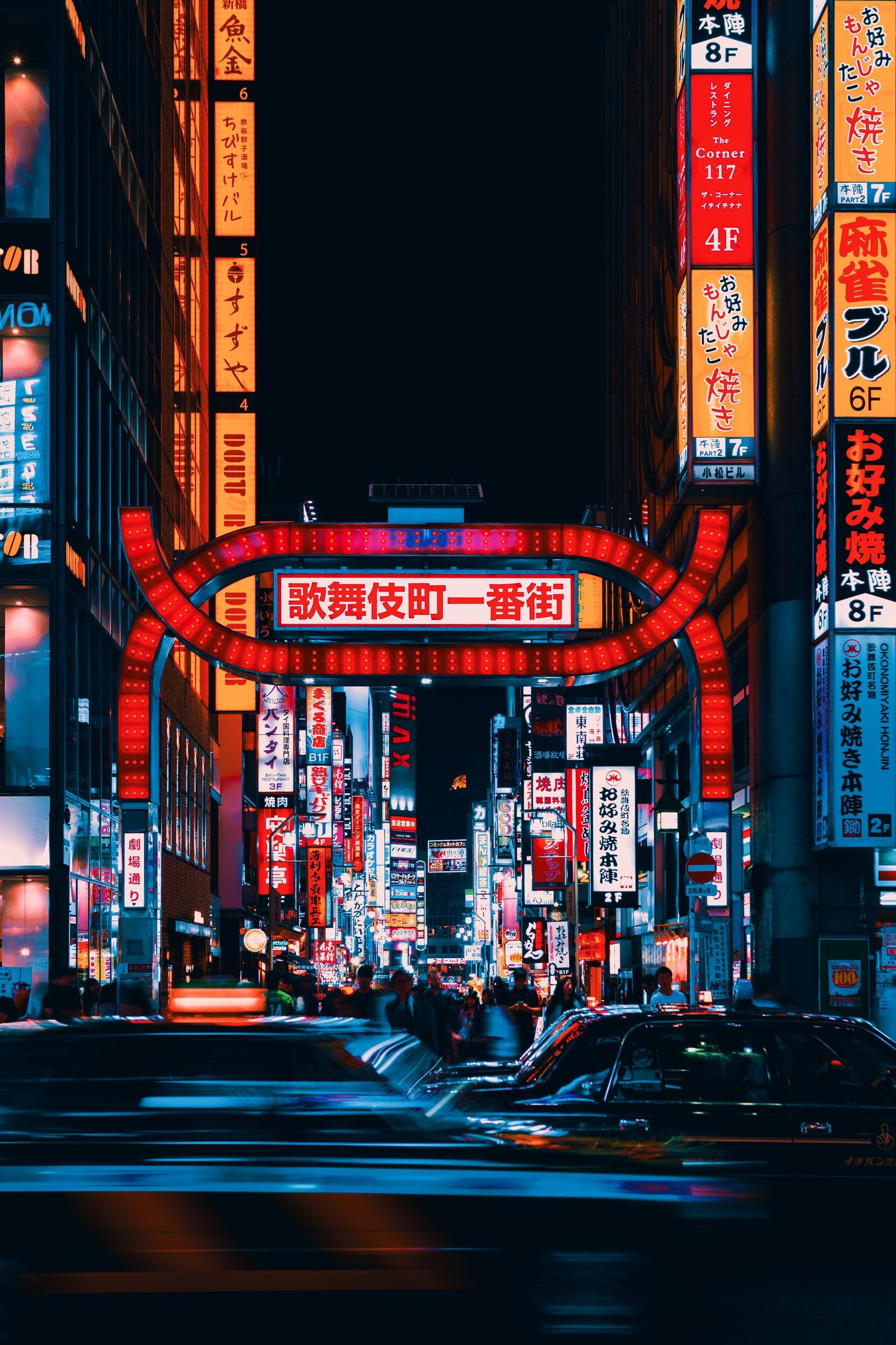 Busy streets of Shinjuku Tokyo with neon lights and traffic